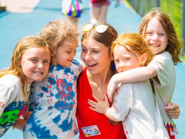 Group of young campers hug CIT.