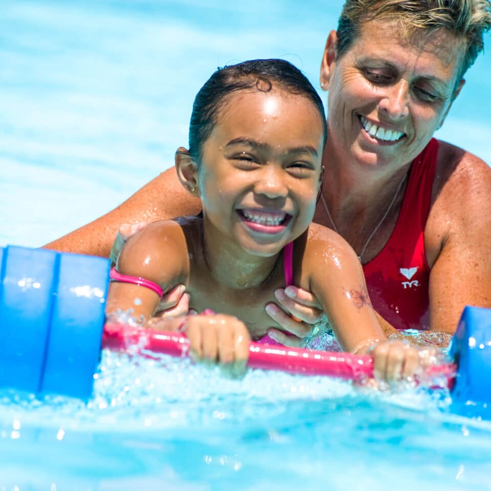 Scout camper in the pool with a counselor.