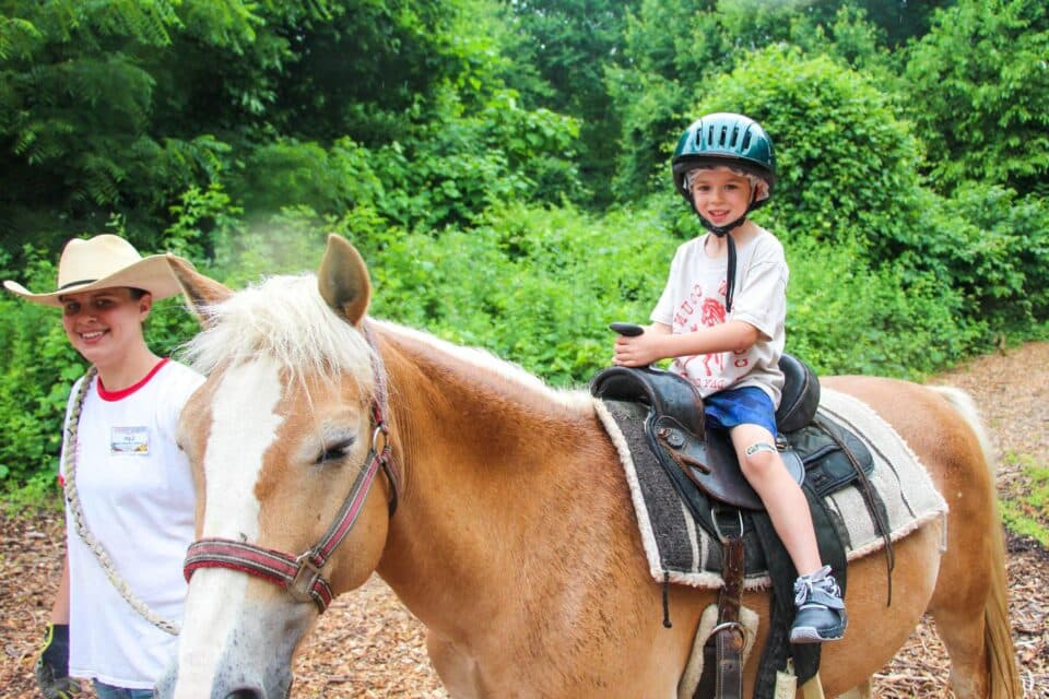 Young boy riding a horse on a trail