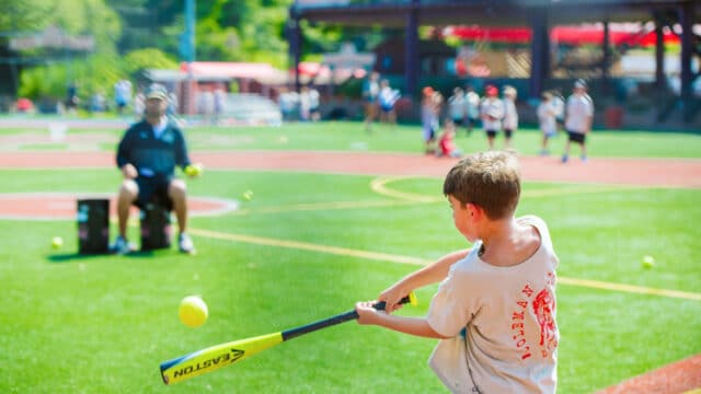 View from behind as camper swing baseball bat