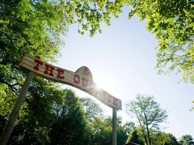 Sun breaks over Outback sign at Coleman County Day Camp