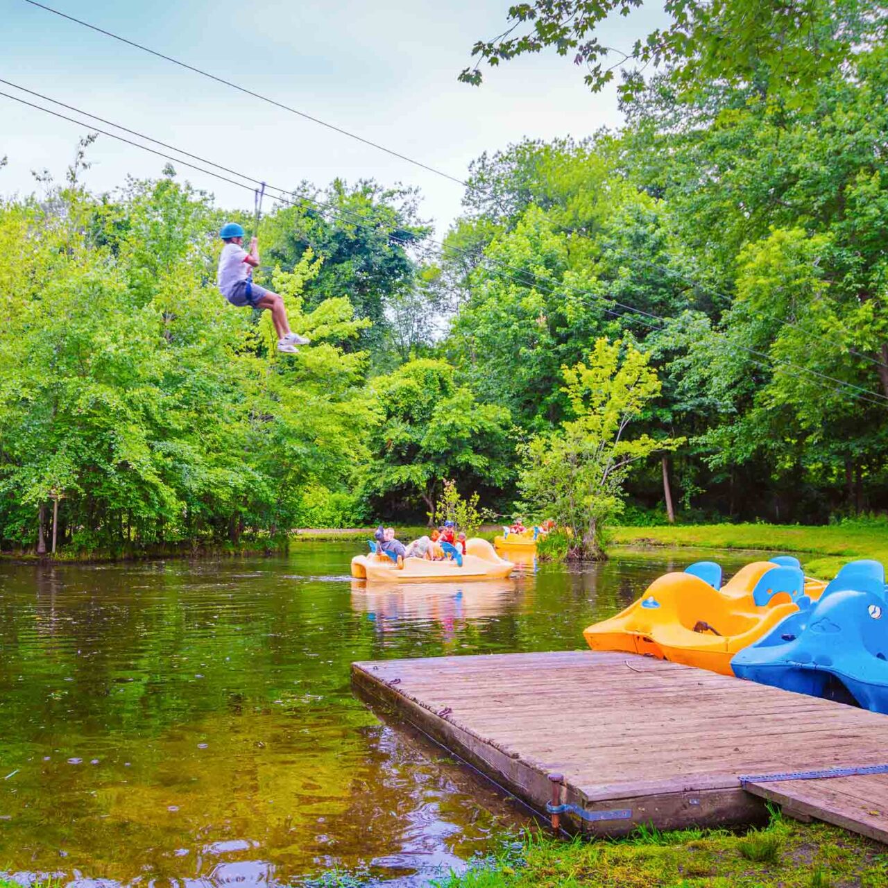 Camper ziplines over pond