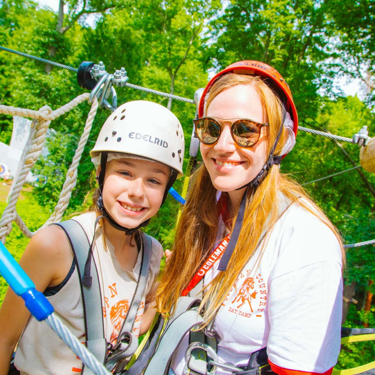 Counselor with camper on the zipline platform smiling together