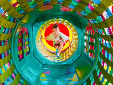 Camper in a play structure tunnel.