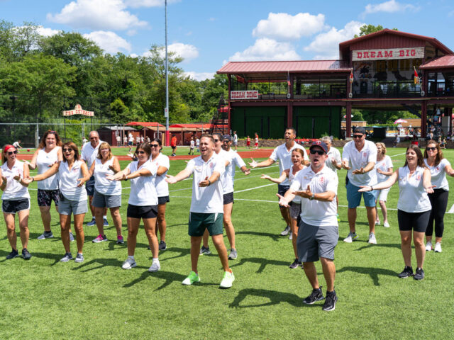 Staff members doing a dance on the field.